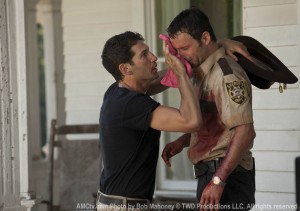 Shane wipes the blood off Rick's face.